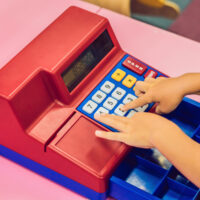 kid playing with a toy cash register