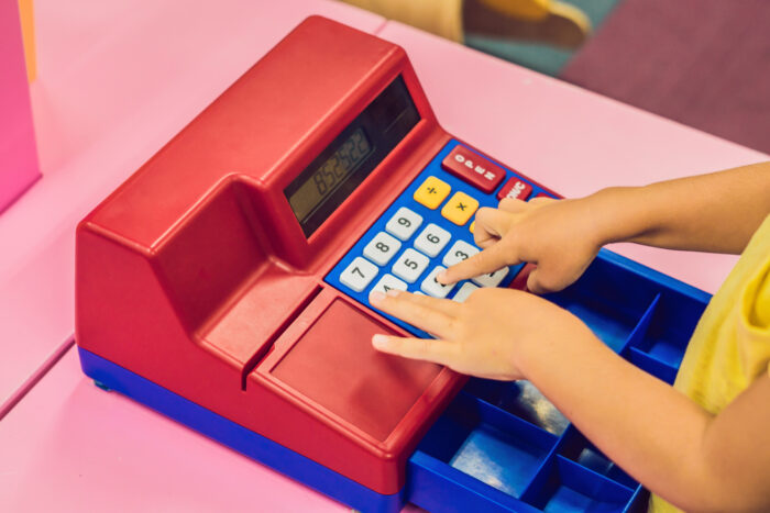 kid playing with a toy cash register
