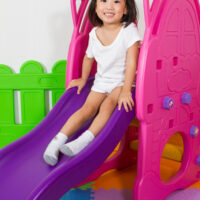 child sliding on slide indoors