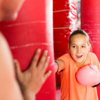 Little girl hitting punching bag