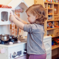 Little Girl Playing in her Play Kitchen