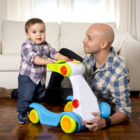 son and father with baby walking toy