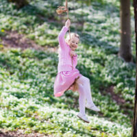 child swinging on rope swing