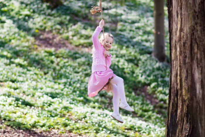 child swinging on rope swing