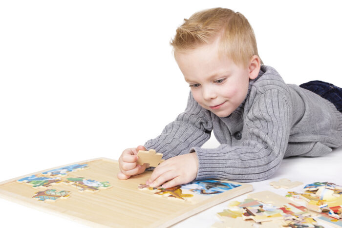 toddler playing with puzzle on floor