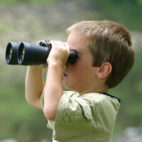 kid looking through binoculars