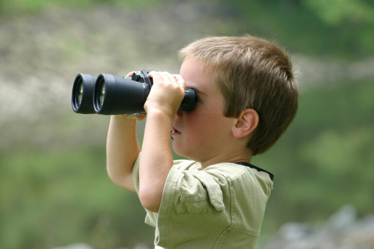 kid looking through binoculars