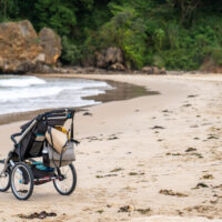 Stroller on beach with bags hanging from it