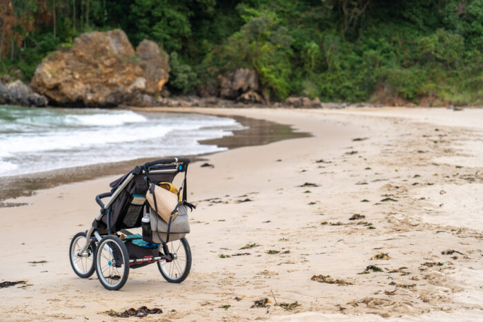 Stroller on beach with bags hanging from it