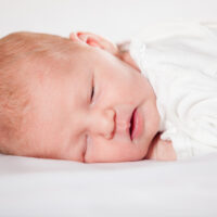 Sleeping baby in white bassinet