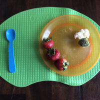 toddler placemat with plate and spoon on it