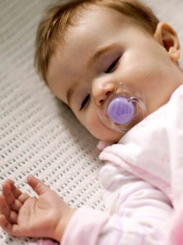 baby in crib with pacifier