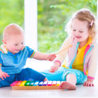 Little Children Making Music with a Xylophone