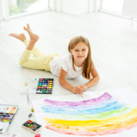 girl laying on the floor painting