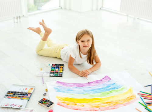 girl laying on the floor painting
