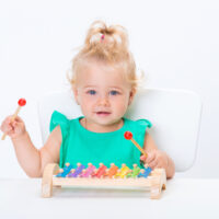 Smiling blonde girl playing xylophones