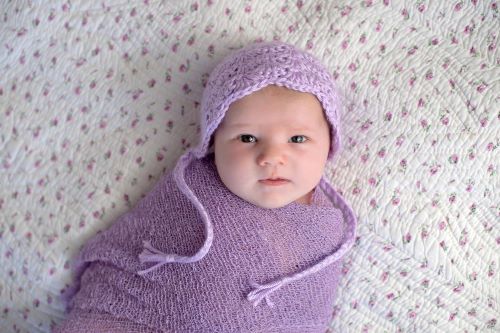 baby swaddled in purple