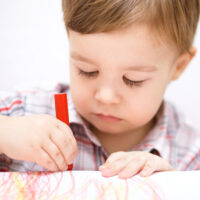 child drawing with crayon