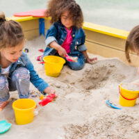 three kids in a sandbox