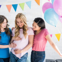 girls with balloons at baby shower