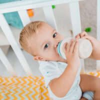 toddler drinking formula from a bottle