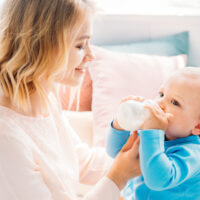mom holding baby drinking pedialyte