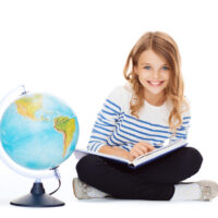 girl sitting with globe and book