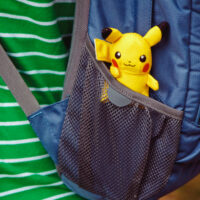 pokemon toy pikachu sitting in backpack pocket