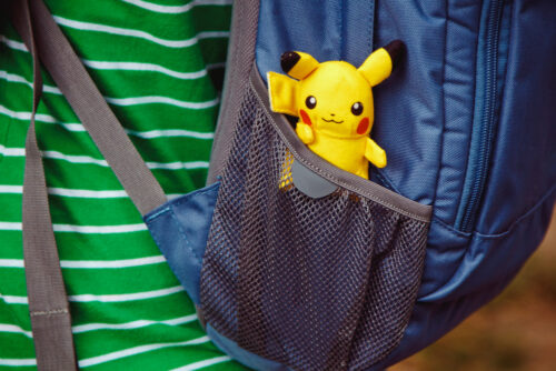 pokemon toy pikachu sitting in backpack pocket