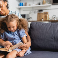 woman reading to child on the couch