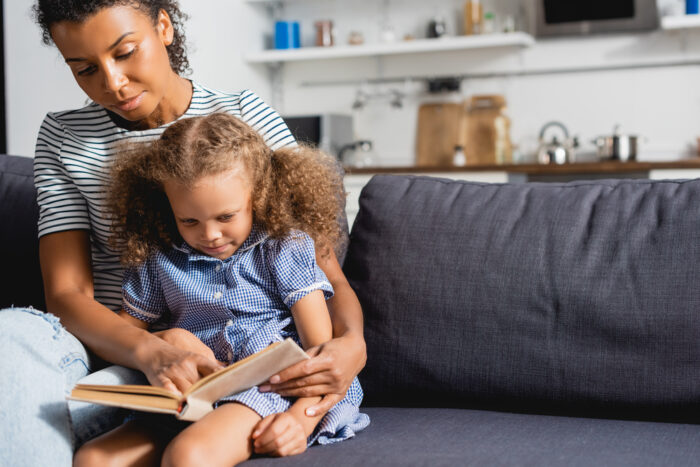 woman reading to child on the couch