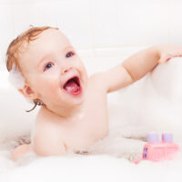 toddler playing in a bubble bath