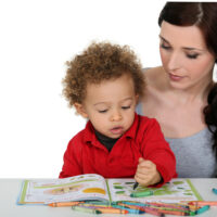 mother and her toddler son coloring in a coloring book together