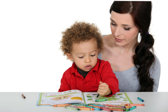 mother and her toddler son coloring in a coloring book together