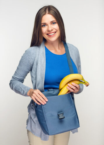 woman putting bananas into her lunch bag