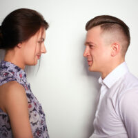 studio shot of young husband and wife talking to each other against white background