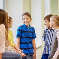 children using social skills to talk in the hallway at school