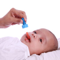 baby taking gripe water through a dropper