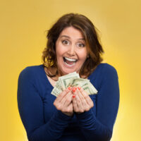 portrait of an excited mom holding lots of cash