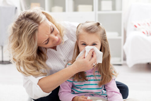 picture of mom helping little girl to blow her nose