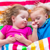 Two Sleeping Toddlers Sleeping in Toddler Bed