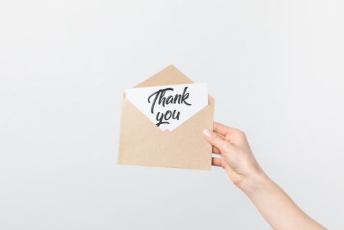 closeup of a woman's hand holding a thank you card