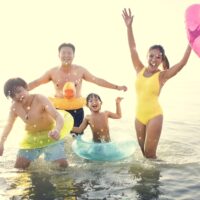 mom in swimsuit at beach with family