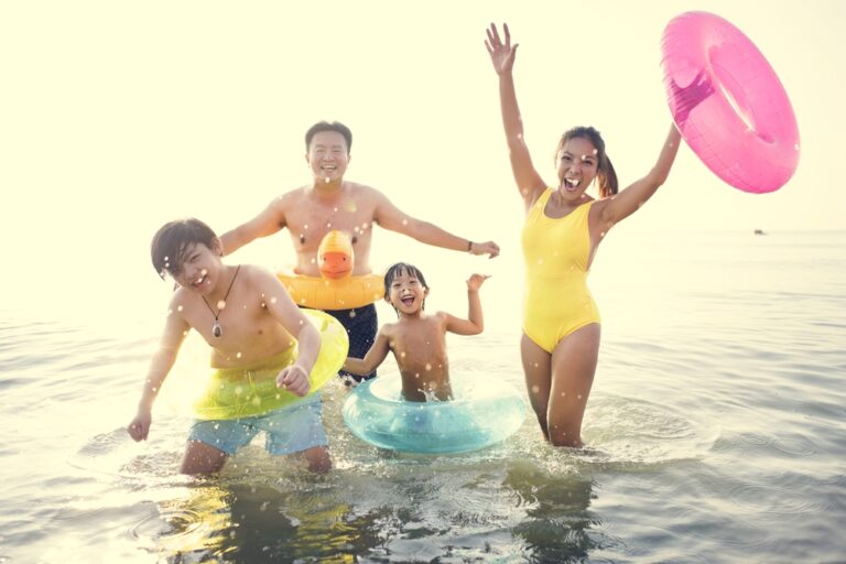 mom in swimsuit at beach with family