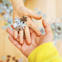 children holding puzzle pieces