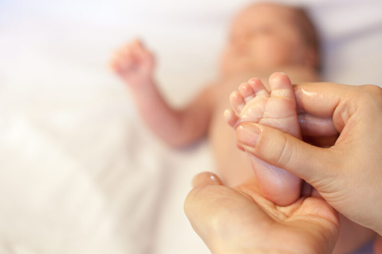 massaging baby oil onto baby foot