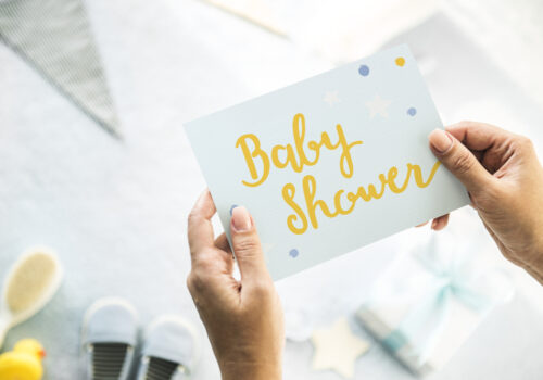 woman holding a baby shower card