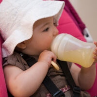 baby drinking juice from a bottle