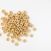 heap of cereal cheerios on white background