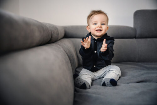 Happy baby boy learning to clap his hands